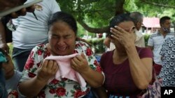 Mujeres lloran mientras explican que tres de sus familiares fueron asesinados el día anterior en El Ripial, estado de Apure, Venezuela, luego de cruzar el río hacia Arauquita, Colombia, el viernes 26 de marzo de 2021. Los venezolanos buscan refugio en Col