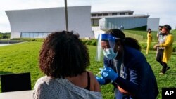 Kendrija Braun, medicinska sestra iz Washingtona, daje vakcinu protiv COVID 19 ženi u blizini Kenedi centra, 6. maja 2021. (Foto: AP) 