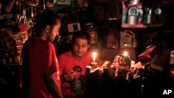 A Bangladeshi salesman interacts with a customer during a blackout in Dhaka, Bangladesh, Nov. 1, 2014.