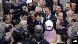 Bức ảnh Tổng thống Syria al-Assad (giữa) bắt tay những người dự lễ tại một đền thờ Hồi giáo vào ngày đầu tiên lễ Eid al-Adha, 26/10/12, do thông tấn xã SANA của Syria công bố 