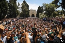 FILE - Worshippers protest against the likely evictions of Palestinians from their homes, after the last Friday prayers of the Muslim holy month of Ramadan at the Al-Aqsa mosque compound in the Old City of Jerusalem, May 7, 2021.