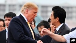 U.S. President Donald Trump, left, shakes hands with Japan's Prime Minister Shinzo Abe, as he leaves the Japanese destroyer JS Kaga, in Yokosuka, south of Tokyo Tuesday, May 28, 2019. 