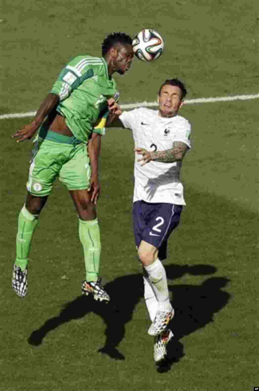 Nigeria's Joseph Yobo, left, and France's Mathieu Debuchy go for a header during the World Cup round of 16 soccer match between France and Nigeria at the Estadio Nacional in Brasilia, Brazil, Monday, June 30, 2014. (AP Photo/Hassan Ammar)