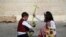 A Palestinian boy and a girl a cross as they attend Easter prayers at the Church of Saint Porphyrius in Gaza City.