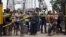 FILE - People stand next to a closed gate as they wait to try to cross La Union international bridge, on the border with Colombia at Boca de Grita in Tachira state, Venezuela, Aug. 29, 2015. 
