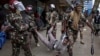 TOPSHOT - Anti-riot police officer arrest a suspected protester during a demonstration against the government in Nairobi, Kenya, on August 8, 2024.