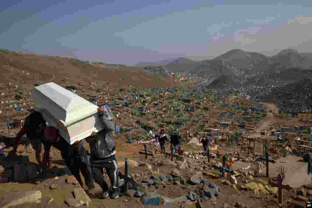 Relatives carry the coffin of a loved one for burial in the section of the Nueva Esperanza cemetery reserved for COVID-19 cases, on the outskirts of Lima, Peru, Sept. 21, 2020.