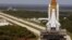 Space Shuttle Discovery, resting on the Mobile Launcher Platform, turns the corner on the crawlerway as it rolls back from Launch Pad 39B to the Vehicle Assembly Building, March 26, 2005. (Image Credit: NASA/KSC)