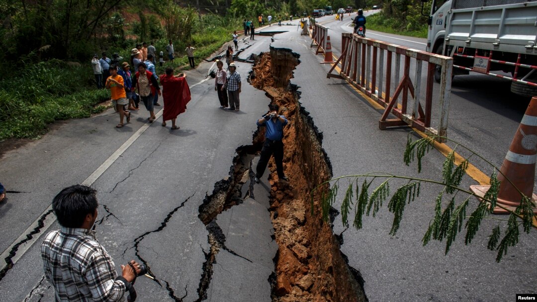 Warga di Chiang Rai, bagian utara Thailand, melintasi jalanan yang rusak akibat gempa (6/5). Gempa bumi berkekuatan 6SR mengguncang wilayah ini hari Senin, 5 Mei 2014.