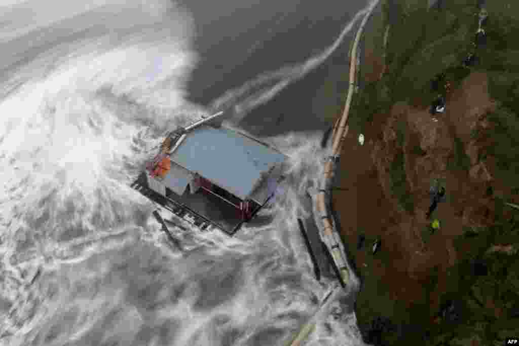 This aerial view shows people looking at the collapsed pier at the Santa Cruz Wharf in Santa Cruz, California, Dec. 23, 2024.&nbsp;A pier collapsed into the ocean and floated away off, weather authorities said, as the region was pounded by a powerful storm.