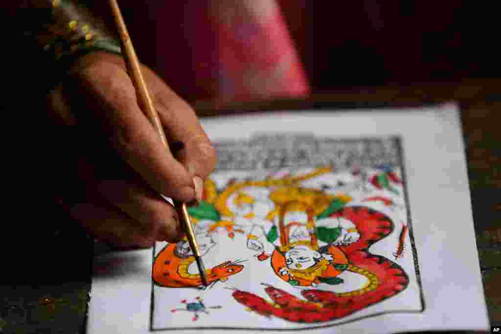 Tej Kumari Chitrakar makes a traditional painting ahead of Naag Panchami festival at her residence in Bhaktapur, Nepal, July 31, 2019.