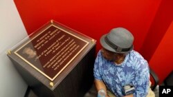 Martin L. Mathews, co-founder of St. Louis' Mathews-Dickey Boys' & Girls' Club, pauses to read a plaque in memory of Michael Brown during the dedication of a new community empowerment center, July 26, 2017, in Ferguson, Mo. 