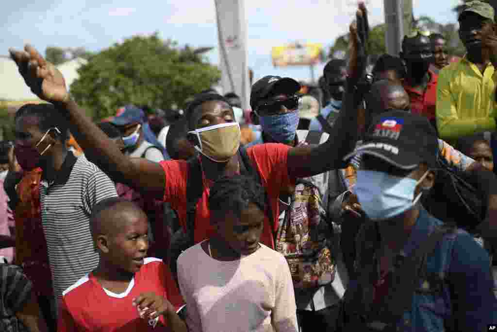 People wanting to apply for U.S. visas react outside the U.S. embassy after learning the embassy will continue to be closed in Port-au-Prince, Haiti.