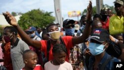 People wanting to apply for U.S. visas react outside the U.S. embassy after learning the embassy will continue to be closed, in Port-au-Prince, Haiti.
