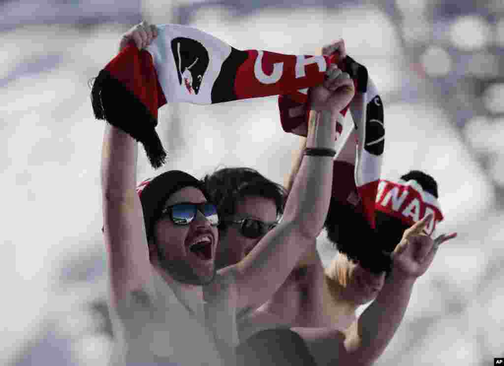 Canadian fans cheer during the men's ski slopestyle qualifying at the Rosa Khutor Extreme Park, at the 2014 Winter Olympics, Feb. 13, 2014.