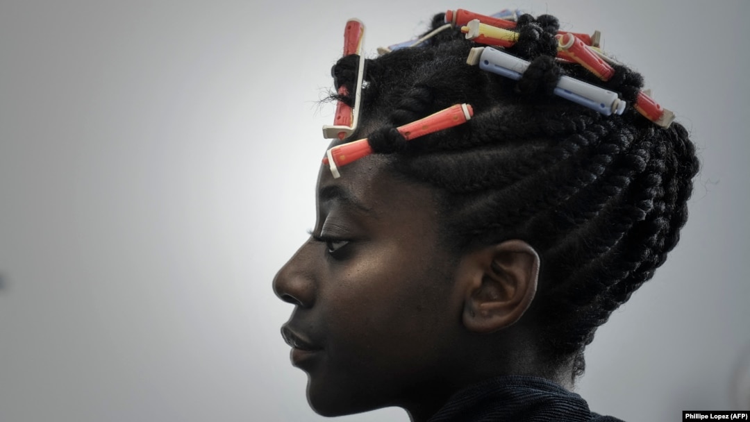 Seorang pelanggan sedang berada di salon tata rambut yang mengkhususkan diri pada perawatan rambut alami afro. (Foto: AFP/Phillipe Lopez)