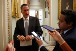 FILE - Republican Senator Mitt Romney speaks with members of the media on Capitol Hill in Washington, March 16, 2020.