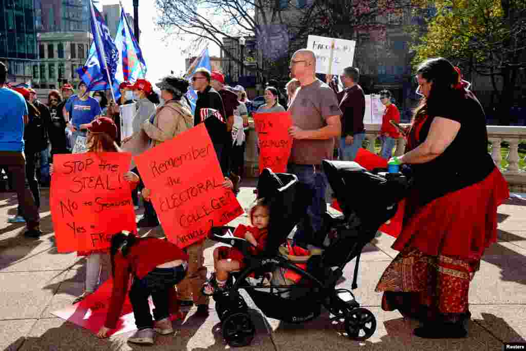 A supporter of U.S. President Donald Trump and her children carry placards at a &quot;Stop the Steal&quot; protest at the Wisconsin State Capitol.