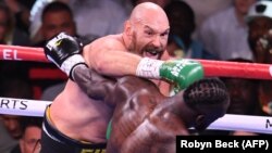 ဗြိတိန်နိုင်ငံသား ဟဲဗီးဝိတ်ချန်ပီယံဟောင်း Tyson Fury (ဘယ်) က အမေရိကန် လက်ဝှေ့အကျော်အမော် Deontay Wilder (ညာ) ကို အလဲထိုးနေစဉ်။ (Photo - AFP )