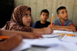 FILE - Children attend an Arabic language lesson given by a Palestinian school girl Fajr Hmaid, 13, as Gaza schools are shut due to the coronavirus disease (COVID-19) restrictions, May 19, 2020.