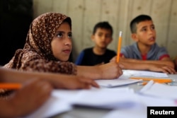 FILE - Children attend an Arabic language lesson given by a Palestinian school girl Fajr Hmaid, 13, as Gaza schools are shut due to the coronavirus disease (COVID-19) restrictions, May 19, 2020.