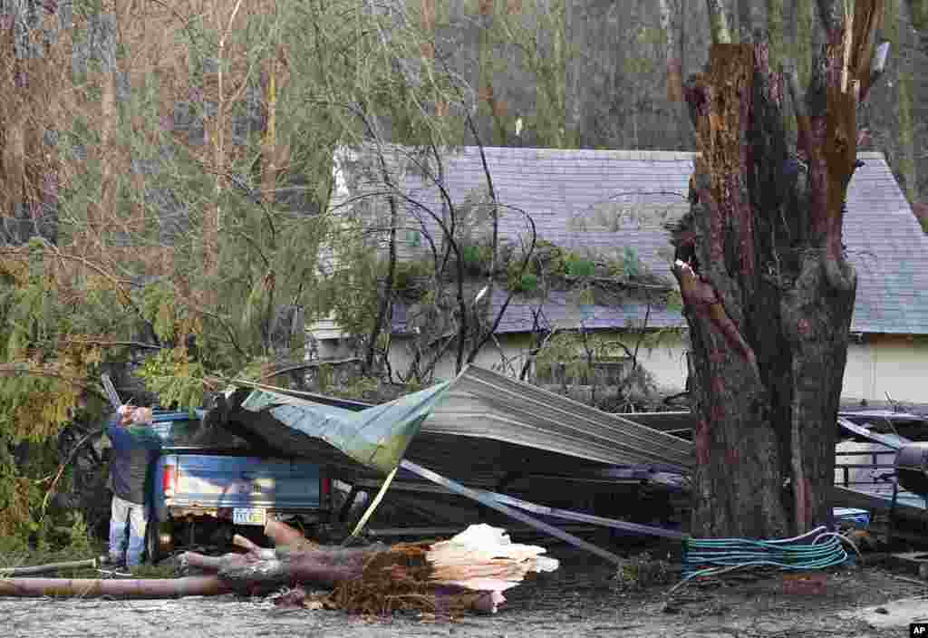 A man cuts trees off his truck after a tornado hit the village of Moscow, Ohio. (AP)