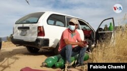 Un boliviano esperando con sus cilindros de oxígeno afuera de la planta de producción en Cochabamba, Bolivia, el 2 de junio de 2021. [Foto: VOA/Fabiola Chambi]