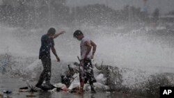 ဖိလစ်ပိုင် ကမ်းရိုးတန်းတလျှောက် တမံတုပ်နေကြသော အလုပ်သမားများနှင့် Usagi မုန်တိုင်းလှိုင်းရိုက်ခတ်လာစဉ်။ (စက်တင်ဘာ ၂၁၊ ၂၀၁၃။)