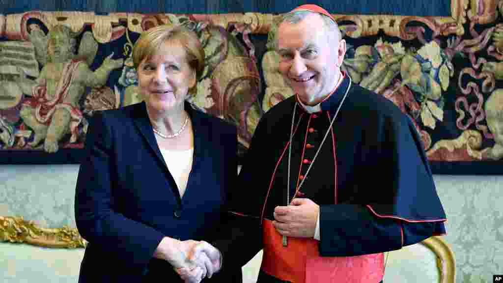 La chancelière allemande Angela Merkel serre la main avec le secrétaire d'État du Vatican, Pietro Parolin, après son auditoire privé avec le pape Francis, au Vatican, le 17 juin 2017.