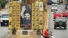 Un hombre en una motocicleta posa junto a un anuncio que representa al líder de Hezbolá en el Líbano, Sayyed Hassan Nasrallah.