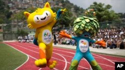 Maskot untuk Olimpiade Rio 2016 (kiri) dan Olimpiade Paralimpik dalam peluncuran perdana di sekolah negeri Santa Teresa di Rio de Janeiro, Brazil (24/11). (AP/Felipe Dana)