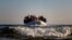 FILE - Refugees and migrants approach the Greek island of Lesbos on a dinghy after crossing the Aegean sea from the Turkish coast, on Monday, Dec. 7, 2015. 