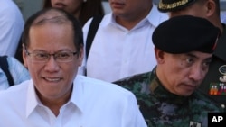 FILE - Philippine President Benigno Aquino walks with New Philippine National Police Special Action Force (SAF) head, Chief Supt. Moro Virgilio Lazo, after the Assumption of Command Ceremony at Camp Bagong Diwa, Taguig, south of Manila, March 4.