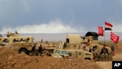 FILE - Smoke rises as the Iraqi army, supported by volunteers, battles Islamic State extremists outside Tikrit, March 4, 2015.