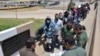 FILE - U.S. Border Patrol officers return a group of migrants back to the Mexico side of the border, as Mexican immigration officials check a list, in Nuevo Laredo, Mexico, July 25, 2019.