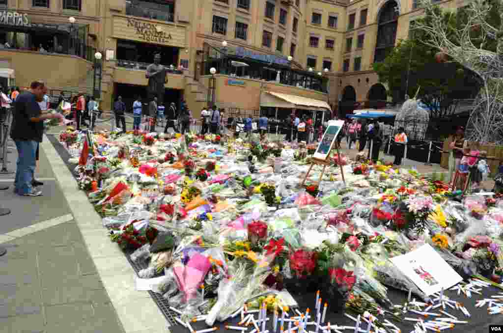 A memorial site set up in Nelson Mandela Square, outside of the Sandton City Mall in Sandton, a suburb north of Johannesburg, Dec. 9, 2013. (Peter Cox for VOA) 