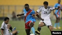 Kaluyituka Dioko de la RDC prend le contrôle de la balle face à Ahmed Khayili de l’Egypte, à droite, lors du match amical RDC-Egypte à Doha, Qatar, 2 mars 2012. 