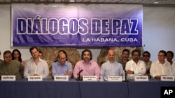 FILE Revolutionary Armed Forces of Colombia (FARC) peace negotiators and Members of Colombia's government negotiating team give a joint statement in Havana, Cuba, June. 4, 2015.