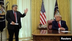 El secretario William Barr, a la izquierda, conversa con el presidente Donald Trump en la Sala Oval de la Casa Blanca.