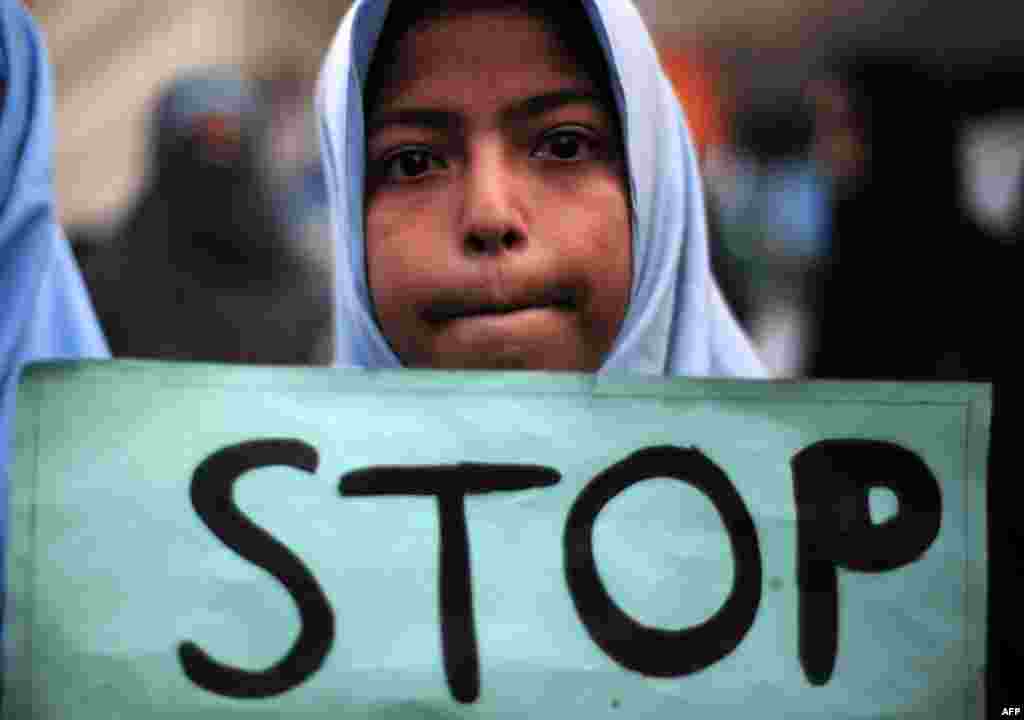 A Shi&#39;ite student of Imamia Students Organization (ISO) holds a placard during a protest against an attack by Taliban militants at an army-run school in Peshawar the previous day, in Karachi.