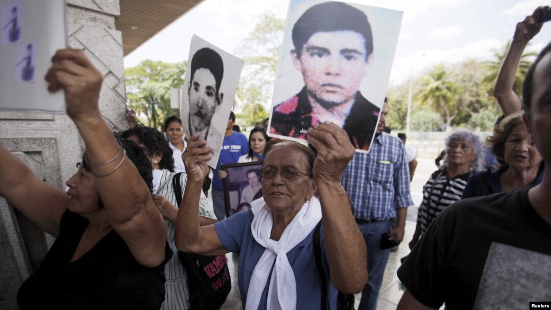 Relatives of war victims protest against Carlos Vides, a former Salvadoran minister of defense, upon his arrival at San Salvador's Oscar Romero airport, April 8, 2015. 