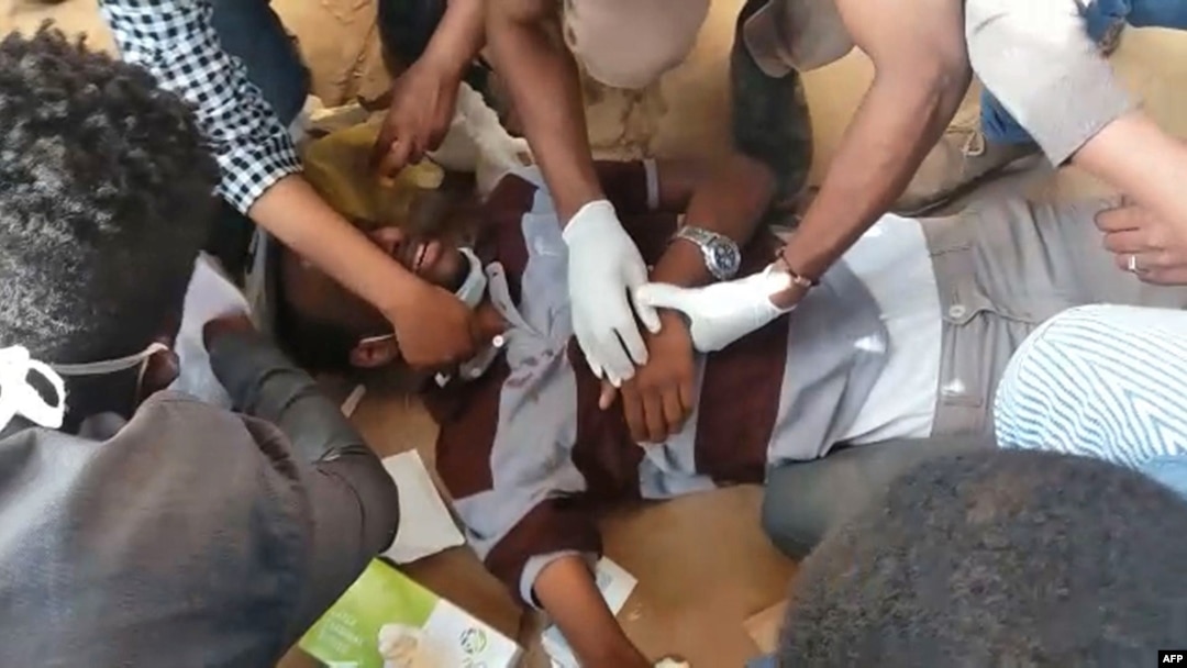 Paramedis merawat seorang pria yang terluka setelah polisi menembakkan gas air mata ke arah ratusan pengunjuk rasa yang berusaha mendatangani istana kepresidenan di Ibu Kota Khartoum dan menuntut pengunduran diri Presiden Sudan, 17 Januari 2019.