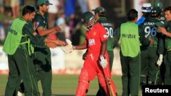 FILE: Zimbabwe's batsman Prosper Utseya (C) leaves the field as Pakistan's players celebrate their win after beating Zimbabwe during their second and last Twenty20 cricket match in Harare September 18, 2011. REUTERS/Philimon Bulawayo (ZIMBABWE - Tags: SPORT CRI