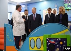Russian President Vladimir Putin, third from left, visits a children's clinic during a trip to Ivanovo, Russia, March 6, 2020.