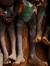 FILE - Orphans and children separated from their parents in Kadugli gather to eat boiled leaves at an internally displaced persons camp in South Kordofan, Sudan, June 22, 2024.