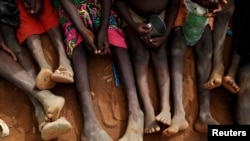 FILE - Orphans and children separated from their parents in Kadugli gather to eat boiled leaves at an IDP Camp within the Sudan People's Liberation Movement-North (SPLM-N) controlled area in Boram County, Nuba Mountains, South Kordofan, June 22, 2024.