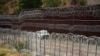 FILE - A vehicle drives along the U.S. side of the U.S.-Mexico border wall in Nogales, Arizona, June 25, 2024. 