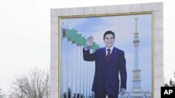 A woman walks past a board displaying a portrait of Turkmenistan's President Kurbanguly Berdymukhamedov in Ashqabat, February 10, 2012.