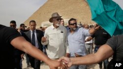 Actor Morgan Freeman, center left, is surrounded by bodyguards as he visits the Giza Pyramids, just outside Cairo, Egypt, Oct. 23, 2015. 