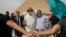 Actor Morgan Freeman, center left, is surrounded by bodyguards as he visits the Giza Pyramids, just outside Cairo, Egypt, Oct. 23, 2015. 